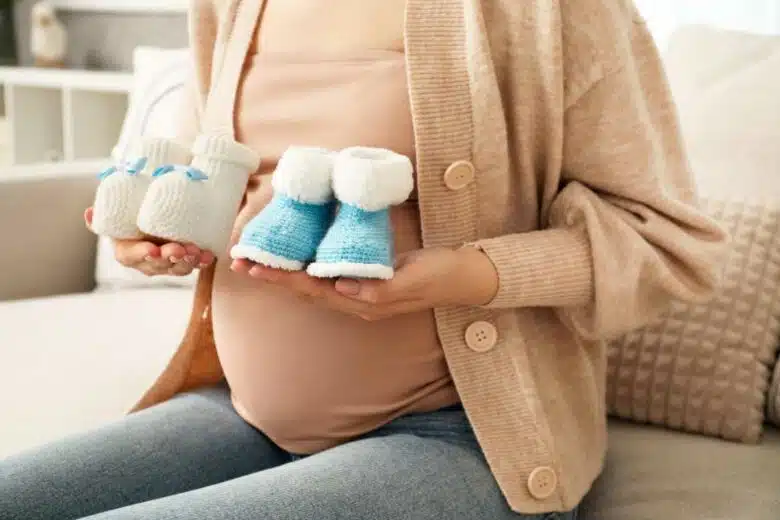 Une femme enceinte avec deux paires de chaussons.