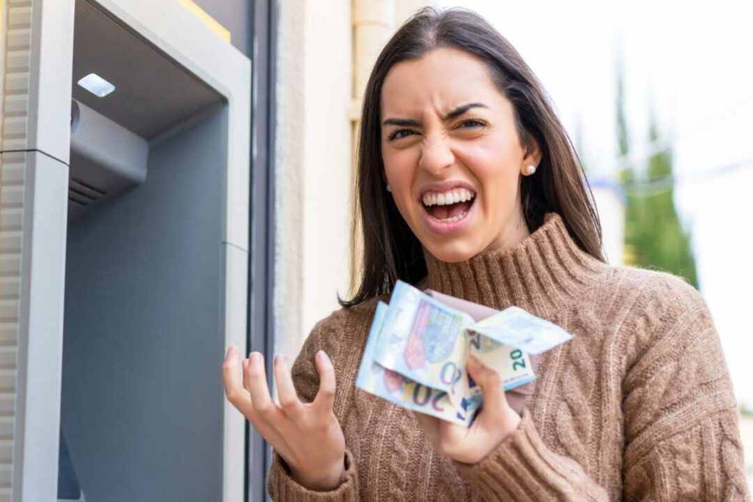 Une femme enrage avec des billets dans les mains.