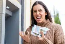 Une femme enrage avec des billets dans les mains.