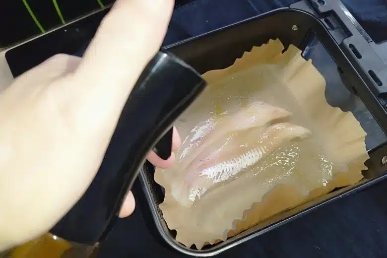 Vaporisation d'huile sur le poisson avant cuisson.