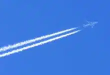 Un avion qui laisse une trainée blanche dans le ciel.