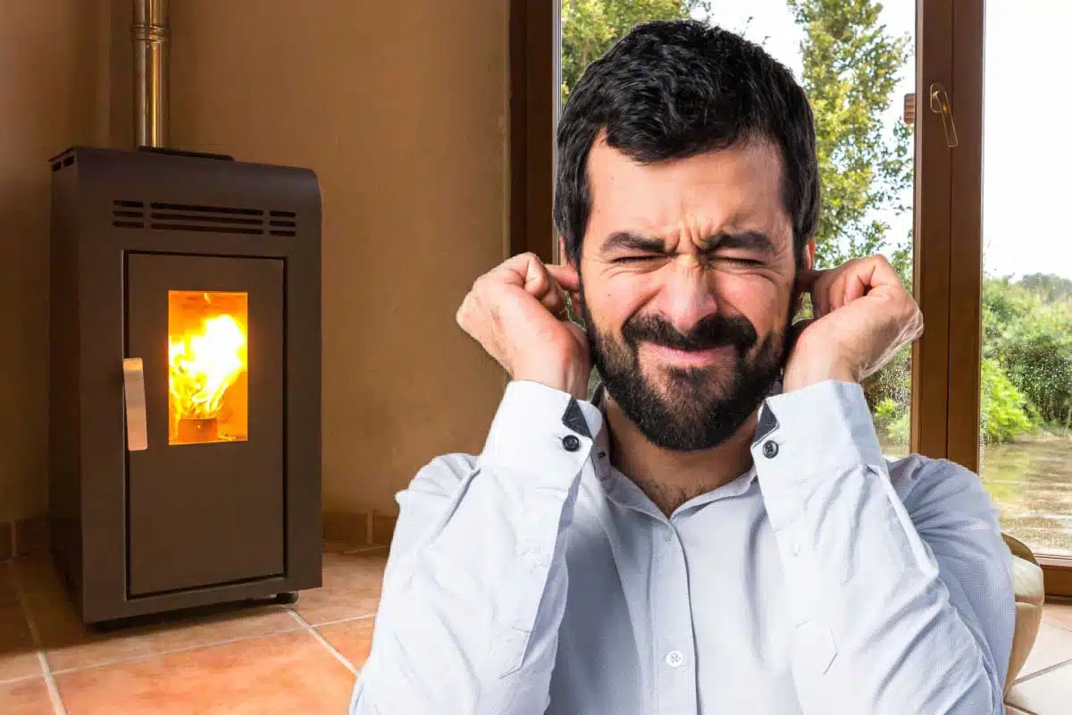 Un homme se bouche les oreilles devant un poêle.