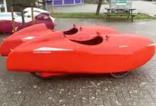 Des vélomobiles Velomobiel.nl sur le parking de l'atelier.