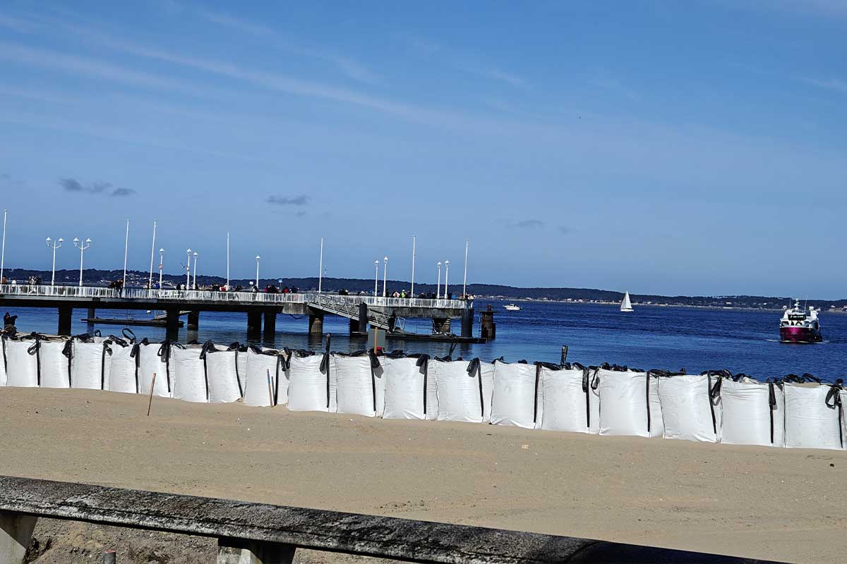 Des sacs de sable en ligne sur une plage.