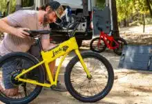 Un homme recharge son vélo électrique avec un kit de panneaux solaires.