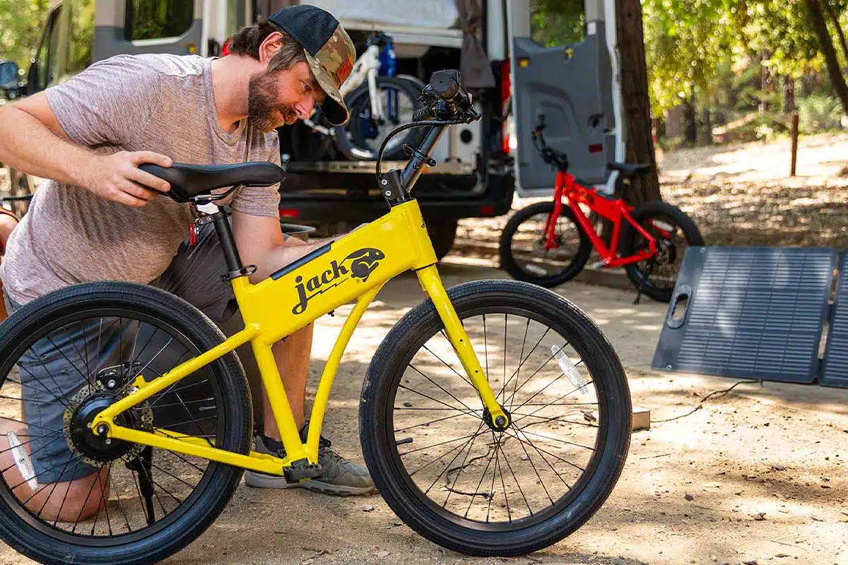 Un homme recharge son vélo électrique avec un kit de panneaux solaires.