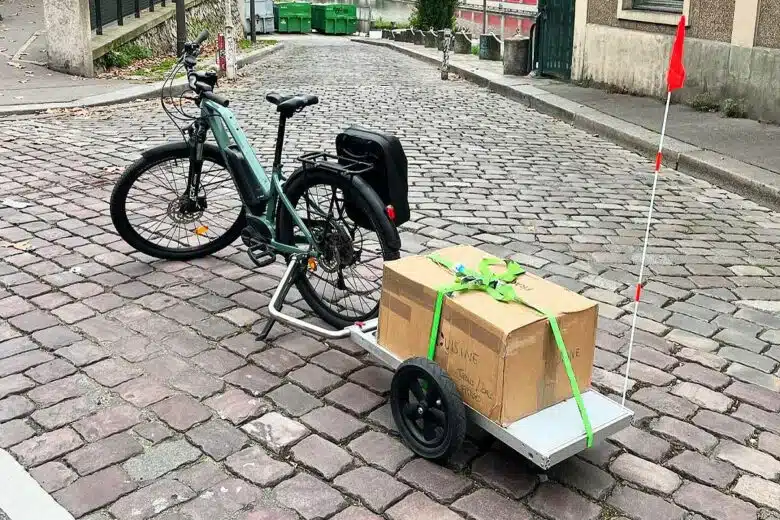 Un vélo avec un Odilo en remorque pour transporter une charge.