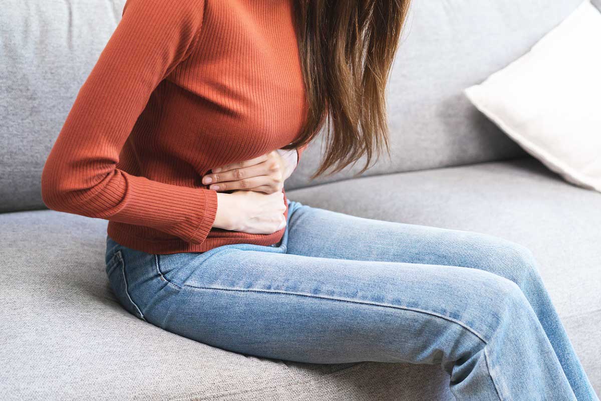 Une femme qui se tient le ventre.