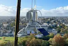 Une éolienne déplacée par une grue pour son installation sur un toit d'immeuble.