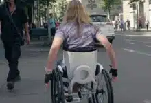 Une personne aux cheveux longs dans un fauteuil roulant.