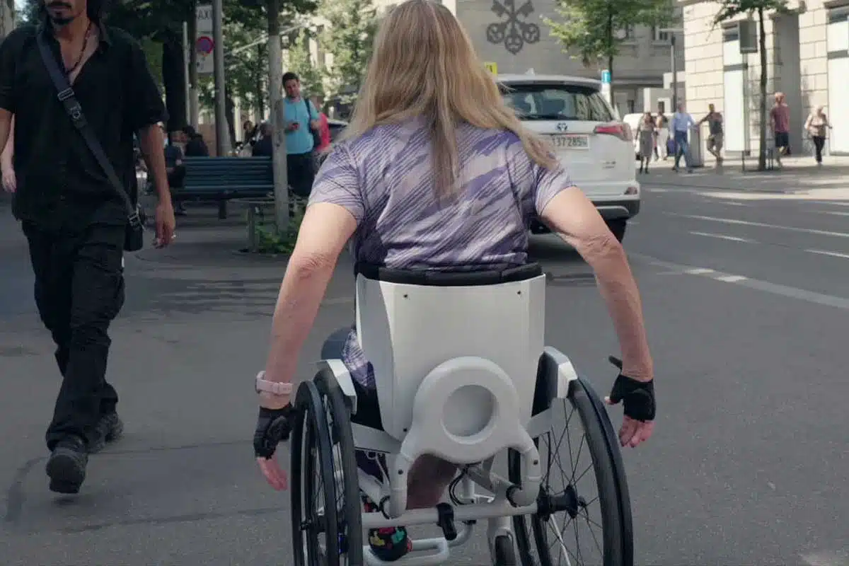 Une personne aux cheveux longs dans un fauteuil roulant.