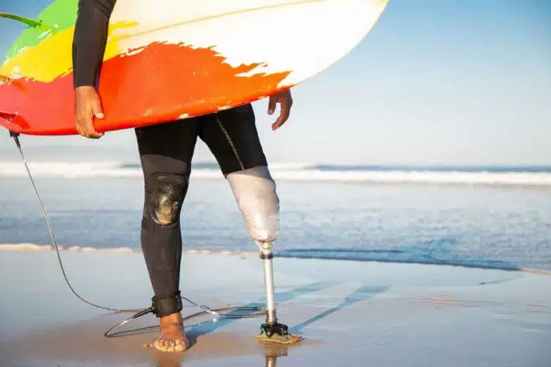 Un surfeur amputé regarde la mer.