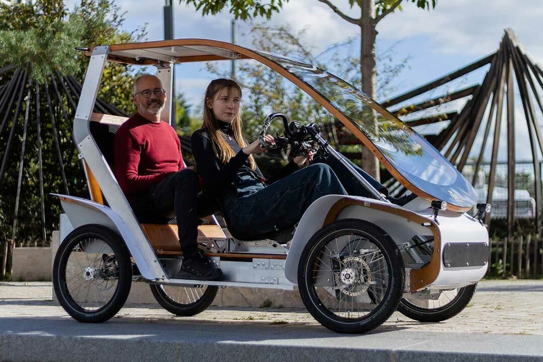 Deux personnes dans un vélomobile Acticycle.