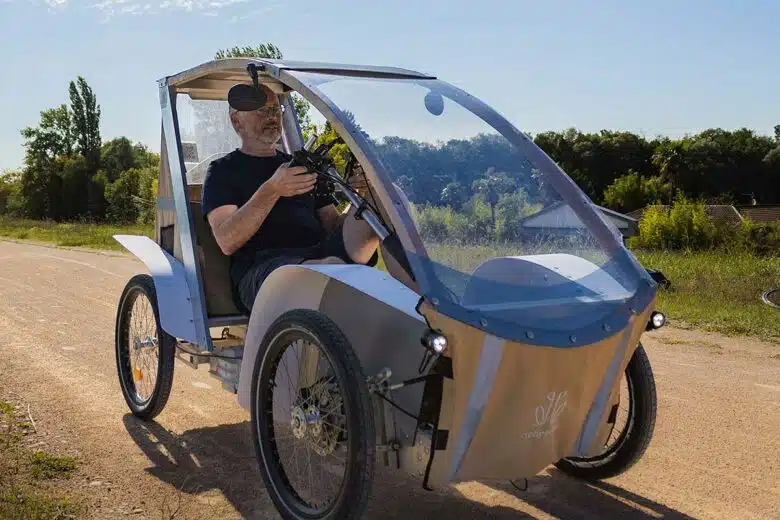 Un homme se déplace dans un vélomobile Acticycle.