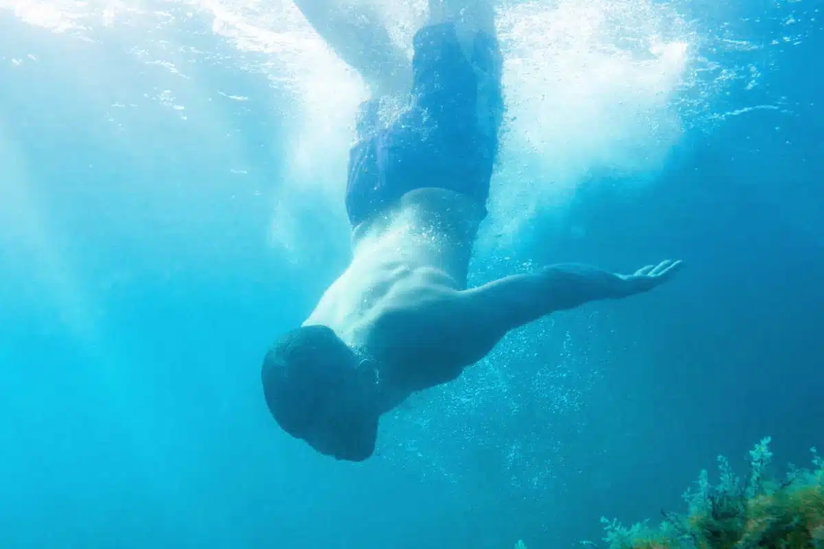 Un homme plonge dans l'eau.