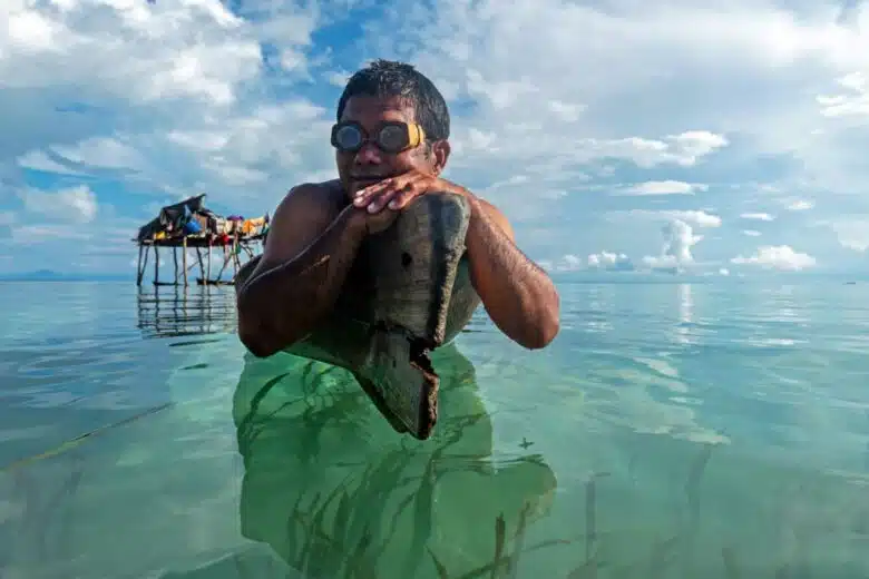 Un homme Bajau attend sur son bateau.