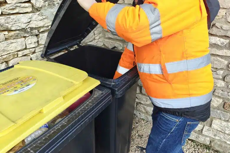 Un homme s'occupe des poubelles.