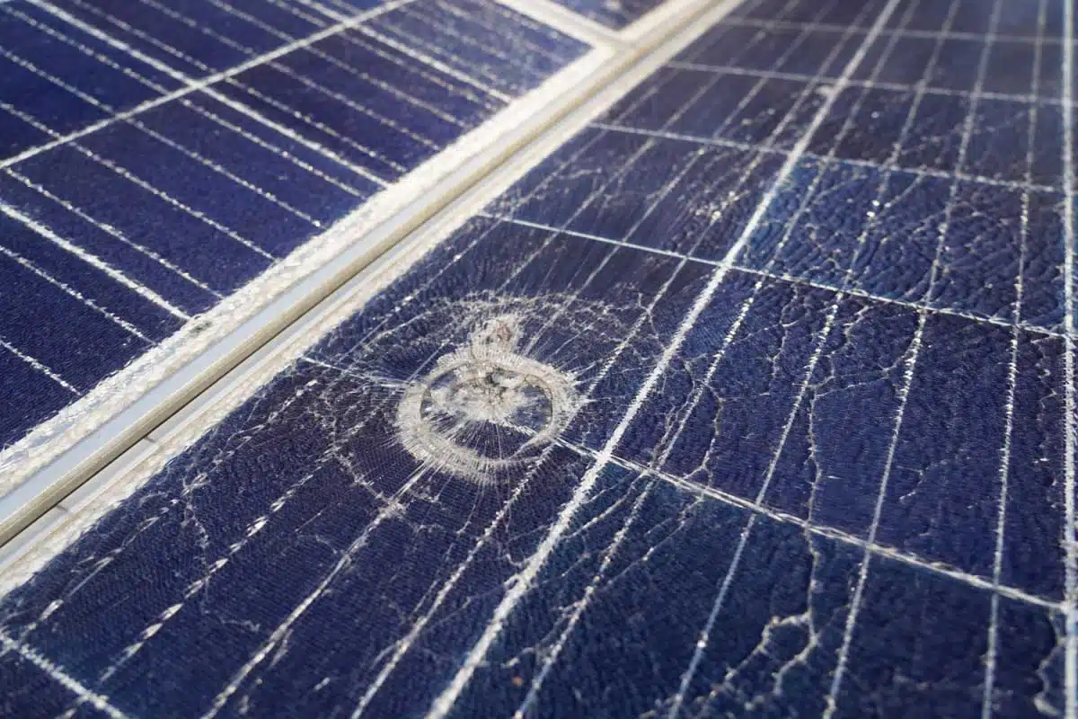 Un panneau solaire brisé avec un impact de grêlon.