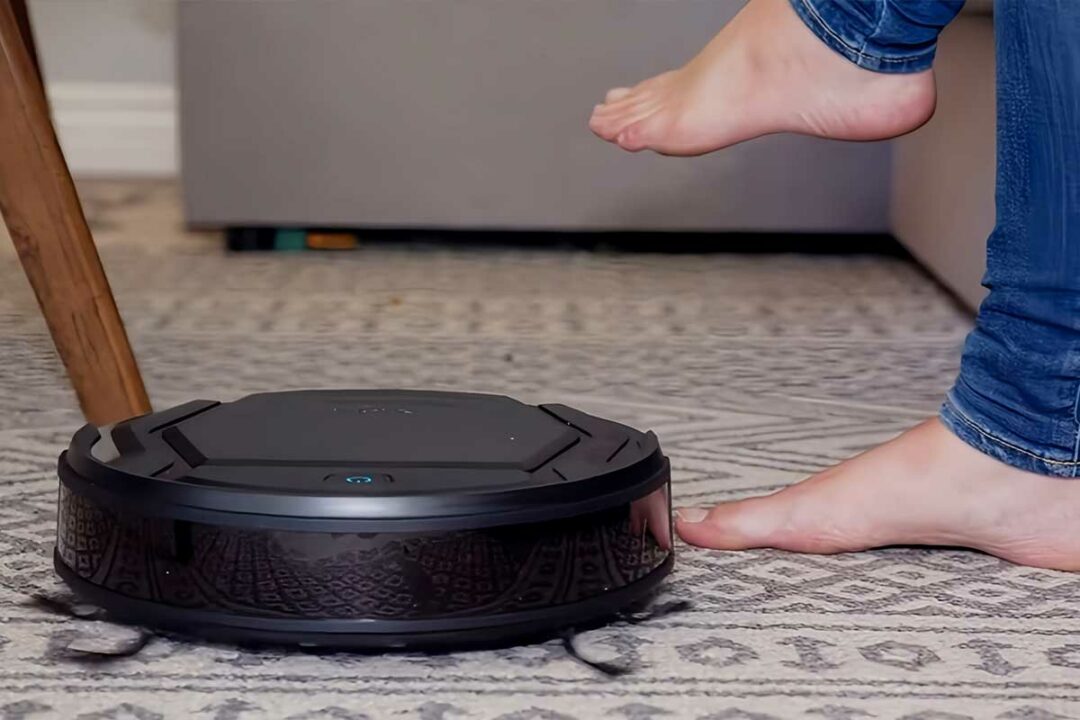 Un robot aspirateur qui passe sous un canapé ou dort une enfant.