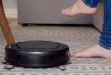 Un robot aspirateur qui passe sous un canapé ou dort une enfant.