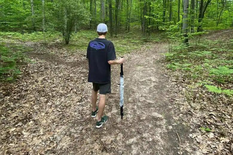 Un homme avec un bâton de randonnée qui peut se transformer en tente.