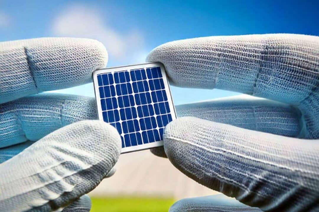 Une cellule photovoltaïque tenue entre les mains.