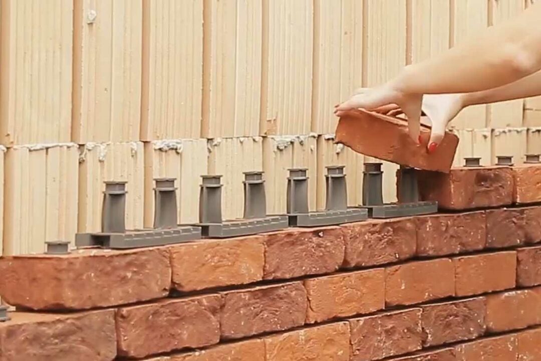 Une femme construit un mur en brique avec Facadeclick.