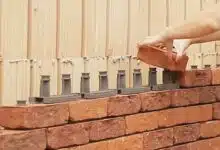 Une femme construit un mur en brique avec Facadeclick.