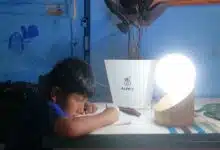 Un enfant fait ses devoirs avec une lumière alimentée par une plante.