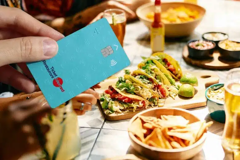 Une personne utilise une carte ticket restaurant pour payer un repas.